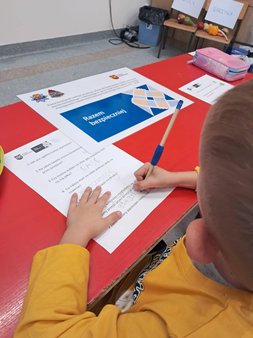 zdjęcie przedstawia wizerunek chłopca piszącego po kartce. 