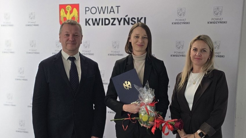 Na zdjęciu widać starostę kwidzyńskiego i 2 kobiety pozujących  na tle ścianki powiatu kwidzyńskiego