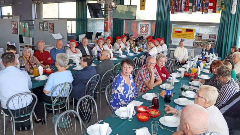 Uczestnicy spotkania „Dnia pieczonego ziemniaka” przy stole.