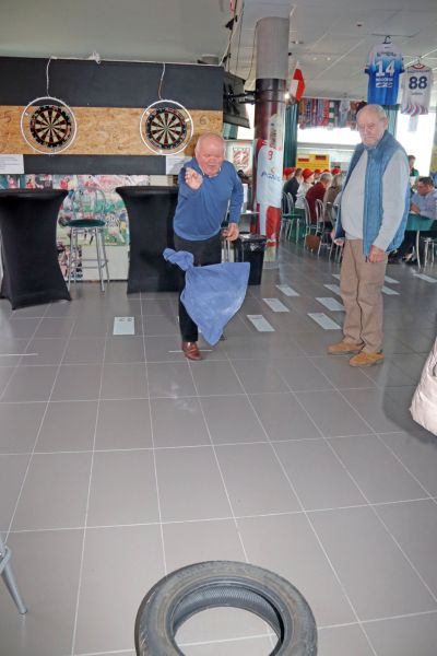 Dwóch mężczyzn uczestniczy w zabawach i konkursach podczas „Dnia pieczonego ziemniaka”.