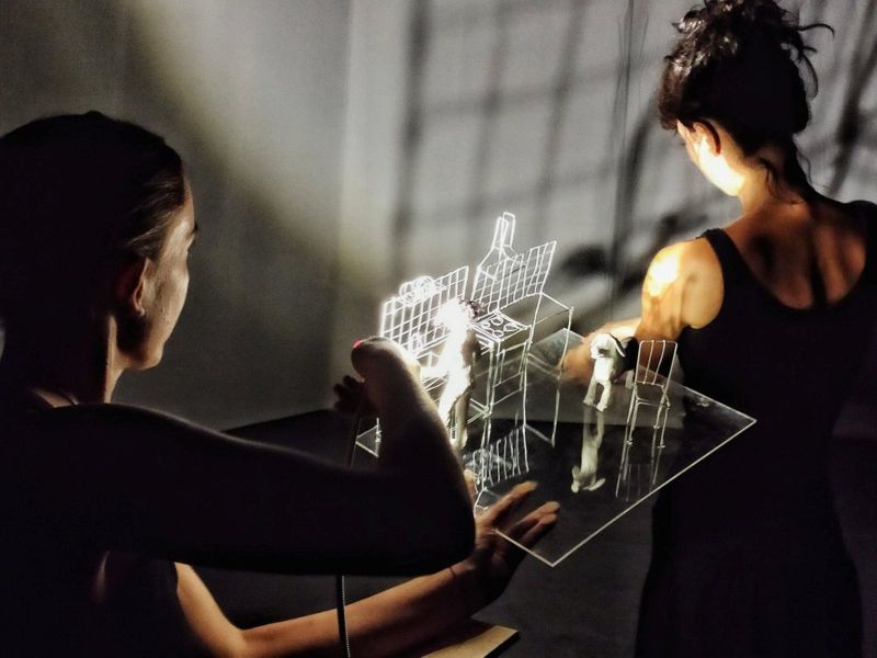 Na zdjęciu znajdują się dwie osoby siedzące przy podświetlanej konstrukcji.