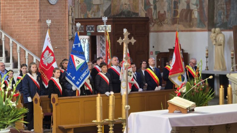 Zdjęcie przedstawia wnętrze katedry, w ławkach stoją delegacje ze sztandarami