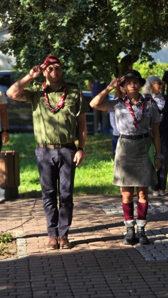 Harcmistrz Andrzej Delewski i harcmistrzyni Wiktoria Wesołowska salutują podczas obchodów 1 września w Kwidzynie.
