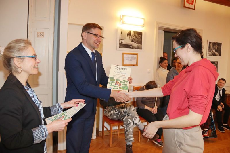 Uczestnicy Warsztatu Terapii Zajęciowej odbierają dyplomy za swoje osiągnięcia. Wręczają je Krzysztof Michalski, zastępca wójta gminy Kwidzyn, oraz opiekunowie WTZ.