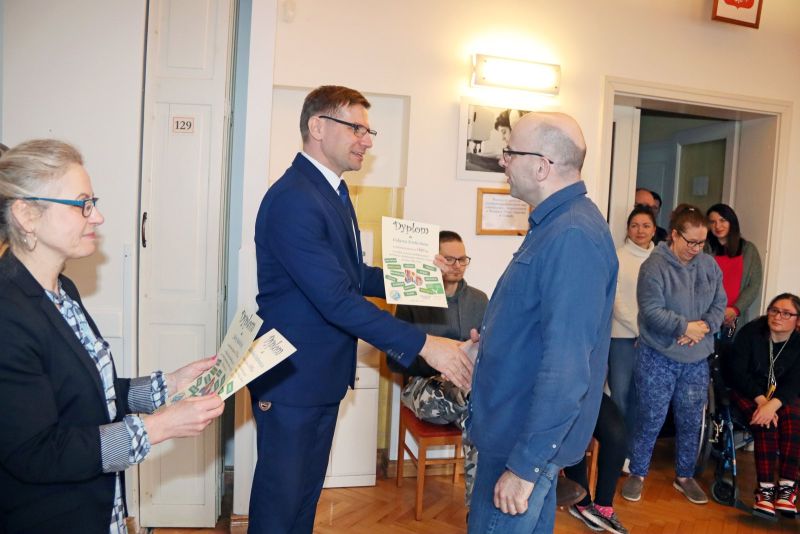 Uczestnicy Warsztatu Terapii Zajęciowej odbierają dyplomy za swoje osiągnięcia. Wręczają je Krzysztof Michalski, zastępca wójta gminy Kwidzyn, oraz opiekunowie WTZ.