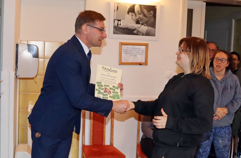 Uczestnicy Warsztatu Terapii Zajęciowej odbierają dyplomy za swoje osiągnięcia. Wręczają je Krzysztof Michalski, zastępca wójta gminy Kwidzyn, oraz opiekunowie WTZ.