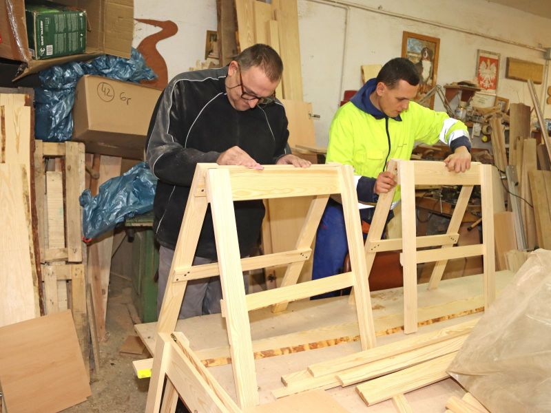 Uczestnik pracowni edukacyjno-stolarskiej z opiekunem.