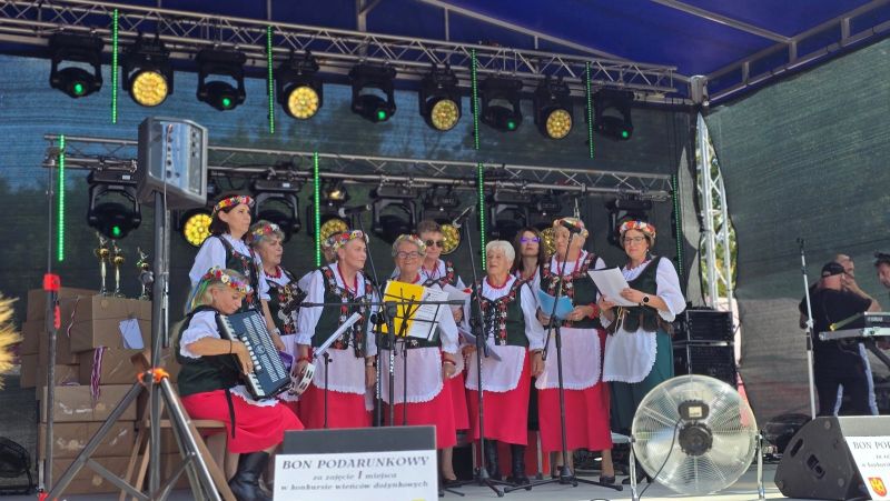 Zespół ludowy występuje na scenie w strojach ludowych.