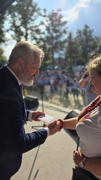 Wójt Gminy Ryjewo wręcza kobiecie kartę upominkową.