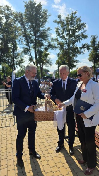 Wójt Gminy Ryjewo częstuje gości chlebem.