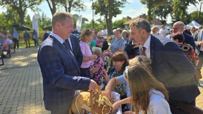 Starosta Powiatu Kwidzyńskiego częstuje mieszkańców chlebem.