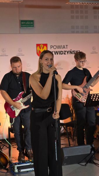  Na zdjęciu widać 7 nagrodzonych w towarzystwie kobiety, w tle ścianka Powiatu Kwidzyńskiego