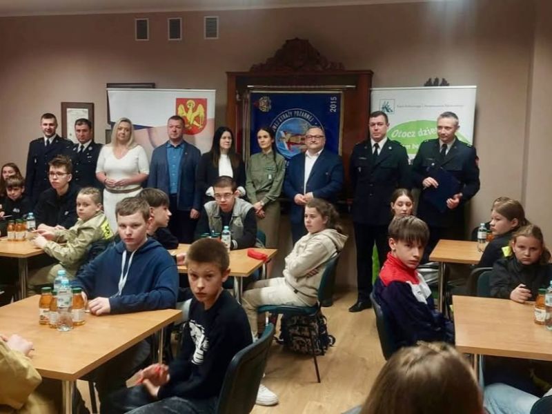 Uczestnicy eliminacji OTWP na sali, w tle obecni samorządowcy i służby mundurowe.