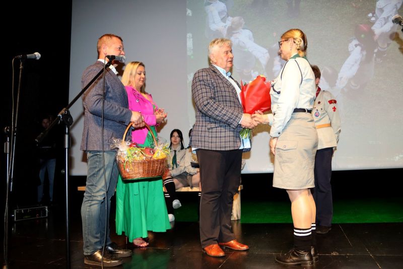 Jerzy Śnieg, przewodniczący rady powiatu, wręcza kwiaty Annie Jankowskiej, dyrektor MOW i drużynowej drużyny „Wesołe Włóczęgi”. Obok stoją Tomasz Frejnagiel, starosta kwidzyński, oraz Katarzyna Ochlik-Rafka, członkini zarządu powiatu. W tle harcerki.