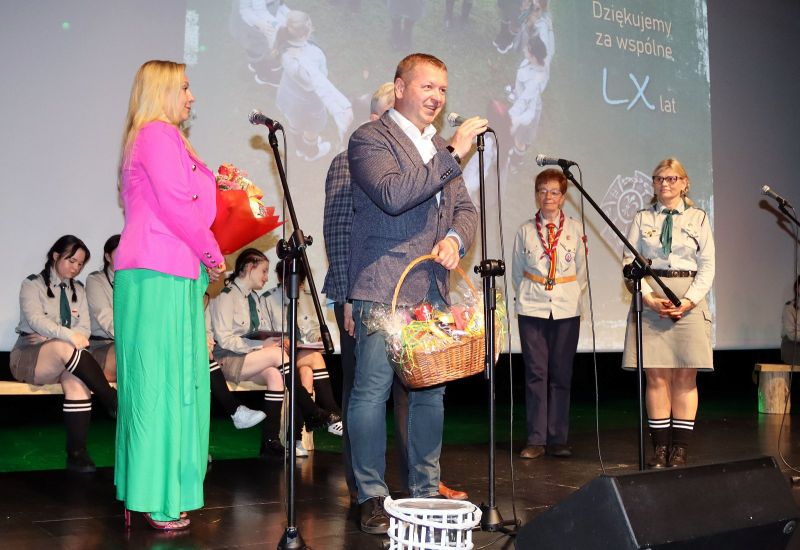 Tomasz Frejnagiel, starosta kwidzyński, przemawia na scenie. Obok stoją Jerzy Śnieg, przewodniczący rady powiatu oraz Katarzyna Ochlik-Rafka, członkini zarządu powiatu. W tle widoczne harcerki z drużyny „Wesołe Włóczęgi”.