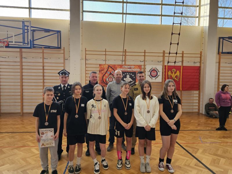 Zdjęcie przedstawia sześcioro dzieci stojących w jednym rzędzie, po wręczeniu medali. Za dziećmi kolejno od prawej strony Tomasz Kazimierczyk, Tomasz Frejnagiel, Łukasz Szczepanowski oraz Damian Torbowski. 