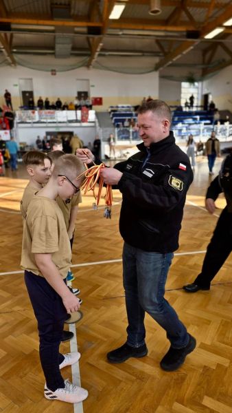 Zdjęcie przedstawia Starostę Tomasza Frejnagiela wręczającego medale uczestnikom turnieju.