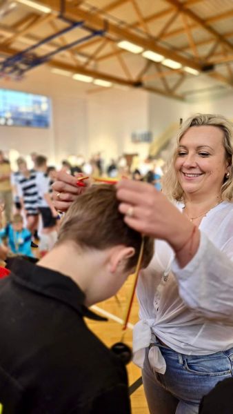 Na zdjęciu widzimy uśmiechniętą Członkinię Zarządu Powiatu Kwidzyńskiego Katarzynę Ochlik-Rafkę wkładającą medal na szyję chłopcu. 