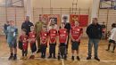 Zdjęcie przedstawia uśmiechnięte dzieci.Za nimi Tomasz Frejnagiel, Piotr Sztypka, Katarzyna Ochlik-Rafka, Tomasz Kazimierczyk oraz trener drużyny.