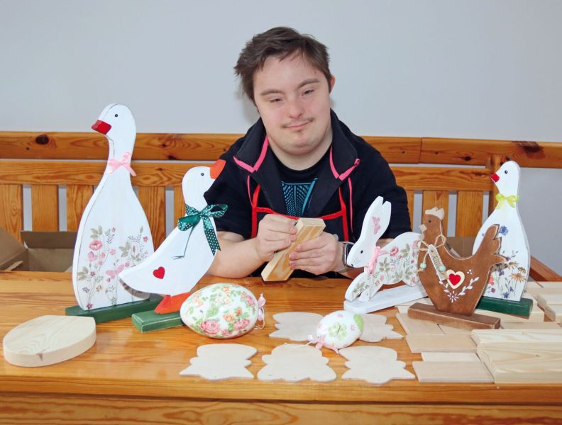 Uczestnik WTZ przygotowujący ozdoby świąteczne.