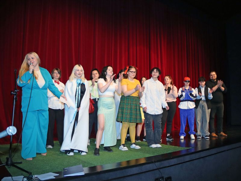 Wszyscy uczestnicy wydarzenia wraz z prowadzącymi stoją razem na scenie.