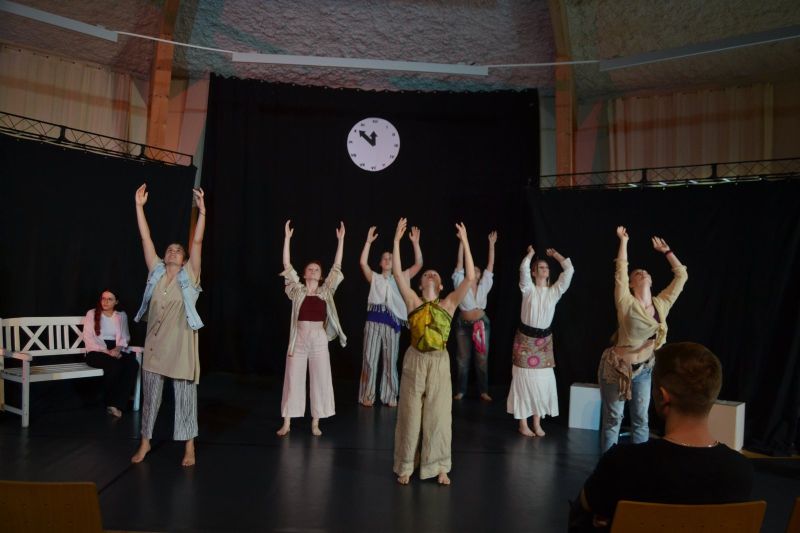 Na zdjęciu widać grupę tańczących osób z rękami podniesionymi do góry.