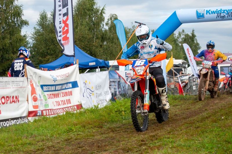 Na zdjęciu znajduje się osoba jadąca na motorze pokazująca kciuk w górę.