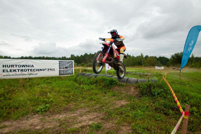 Na zdjęciu znajduje się osoba na motorze, która jest w powietrzu.