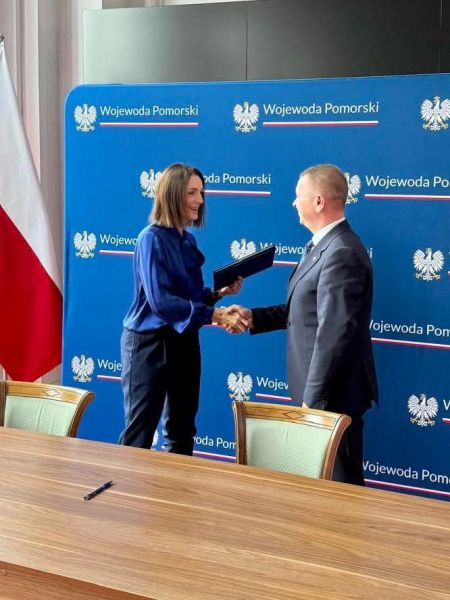 Uścisk dłoni między starostą Tomaszem Frejnagielem a wojewodą Beatą Rutkiewicz po podpisaniu umowy.