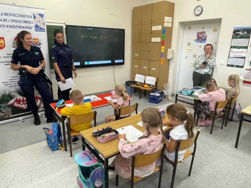 zdjęcie przedstawia dwie policjantki podczas zajęć z dziećmi w szkole oraz panią nauczycielkę. 