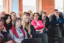 przedstawia grupę ludzi podczas konferencji. 