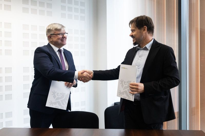 zdjęcie przedstawia dwóch mężczyzn podających sobie ręce. 