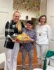 Na zdjęciu nr 5 są trzy kobiety. Dwie trzymają kosz ze słodyczami.
