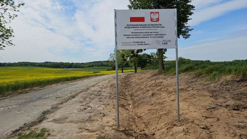 tablica informacyjna na tle remontowanej drogi powiatowej Raniewo-Kleczewo.