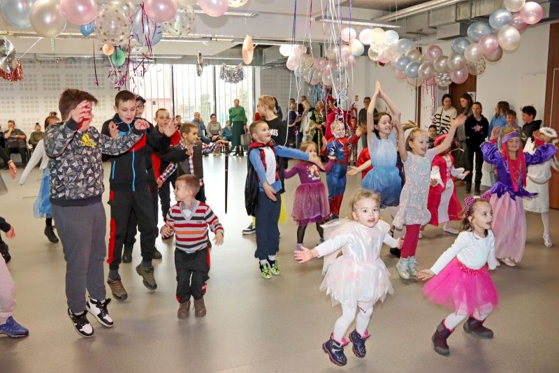 Dzieci tańczą i bawią się w rytm muzyki podczas balu, pełne radości i energii.