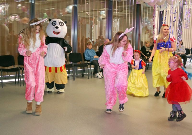 Dzieci uczestniczą w zabawach, które organizują animatorzy, ciesząc się wspólnym czasem.