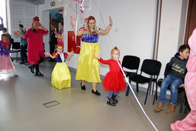 Animatorzy bawią się z dziećmi, które radośnie biorą udział w karnawałowych zabawach.