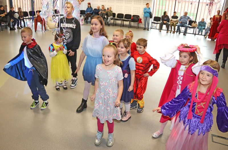 Dzieci bawią się w różne gry i zabawy podczas balu karnawałowego, uśmiechając się i ciesząc wspólnym czasem.