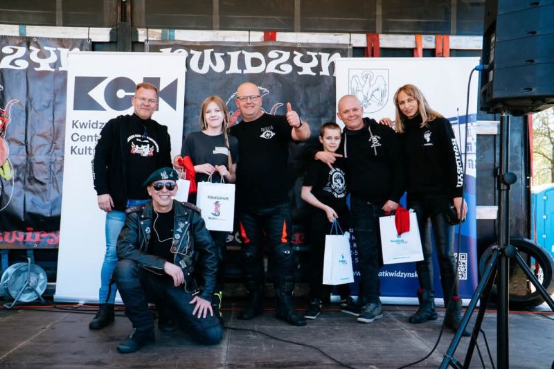 zdjęcie przedstawia siedmioosobową grupę ludzi, na tle motocykla oraz roll-upa powiatu kwidzyńskiego.