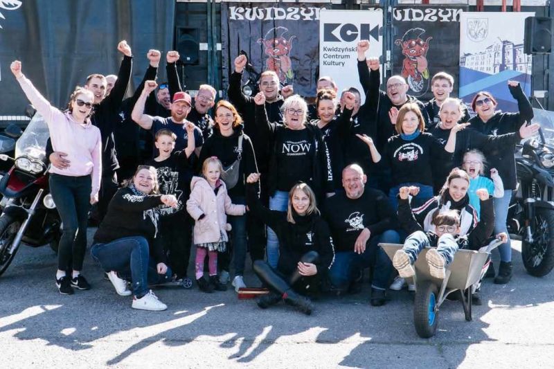 zdjęcie przedstawia grupę ludzi, z uniesionymi rękoma w górę. 