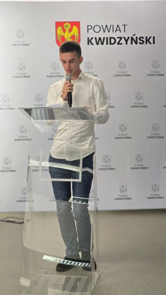 Na zdjęciu widać mężczyznę przemawiającego na tle ścianki powiatu kwidzyńskiego Na zdjęciu widać mężczyznę przemawiającego na tle ścianki powiatu kwidzyńskiego