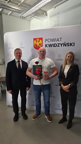 Na zdjęciu widać starostę kwidzyńskiego, kobietę i mężczyznę pozujących na tle ścianki powiatu kwidzyńskiego Na zdjęciu widać starostę kwidzyńskiego, kobietę i mężczyznę pozujących na tle ścianki powiatu kwidzyńskiego