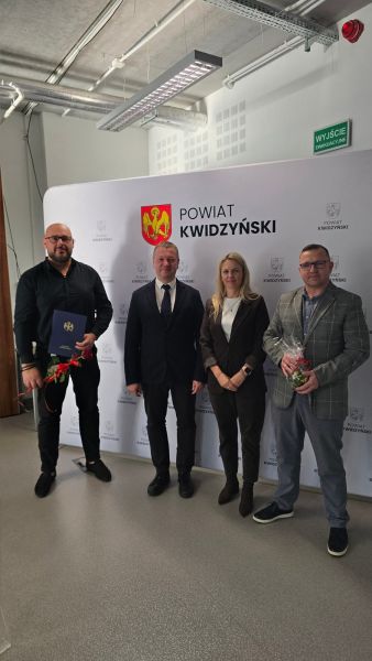 Na zdjęciu widać starostę kwidzyńskiego, kobietę i dwóch mężczyzn pozujących na tle ścianki powiatu kwidzyńskiego Na zdjęciu widać starostę kwidzyńskiego, kobietę i dwóch mężczyzn pozujących na tle ścianki powiatu kwidzyńskiego