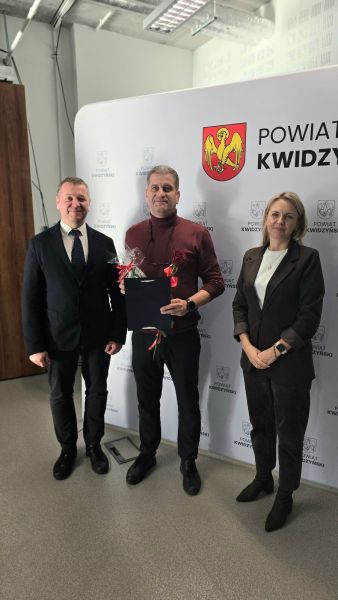 Na zdjęciu widać starostę kwidzyńskiego, kobietę i mężczyznę pozujących na tle ścianki powiatu kwidzyńskiego Na zdjęciu widać starostę kwidzyńskiego, kobietę i mężczyznę pozujących na tle ścianki powiatu kwidzyńskiego