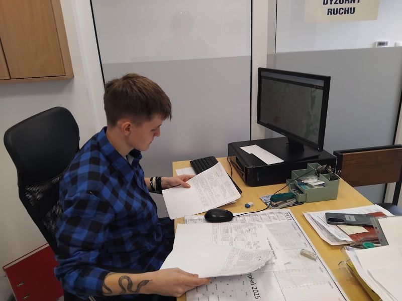 zdjęcie przedstawia stażystę podczas stażu uczniowskiego przeglądającego dokumenty;
