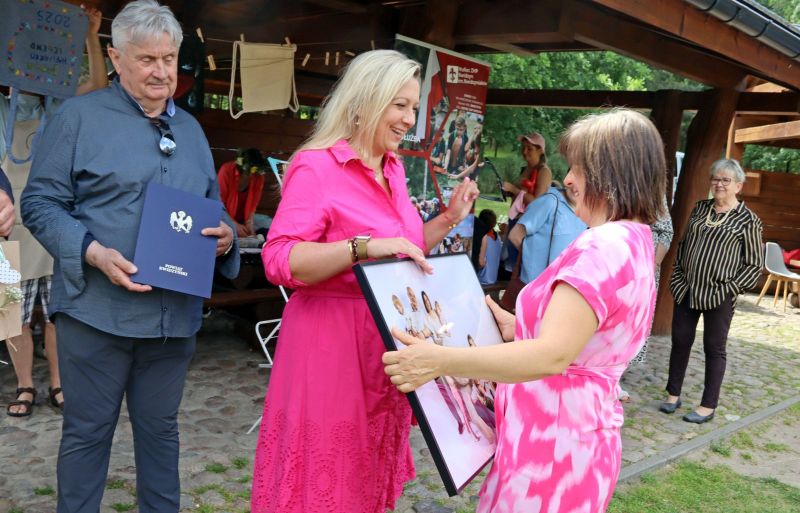 Od lewej przewodniczący Jerzy Śnieg i członkini zarządu Katarzyna Ochlik Rafka wręczają fotografię rodziny zastępczej