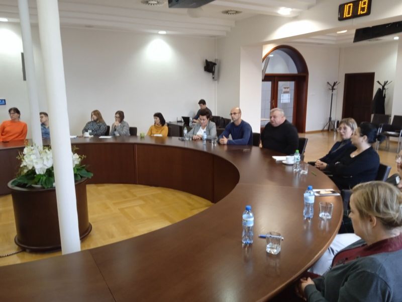 Pierwsza grupa osób uczestnicząca w szkoleniu na miejscach siedzących przy okrągłym stole konferencyjnym