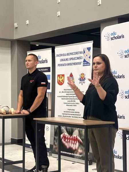 Na zdjęciu widać dwie osoby tłumaczące jakiś temat.