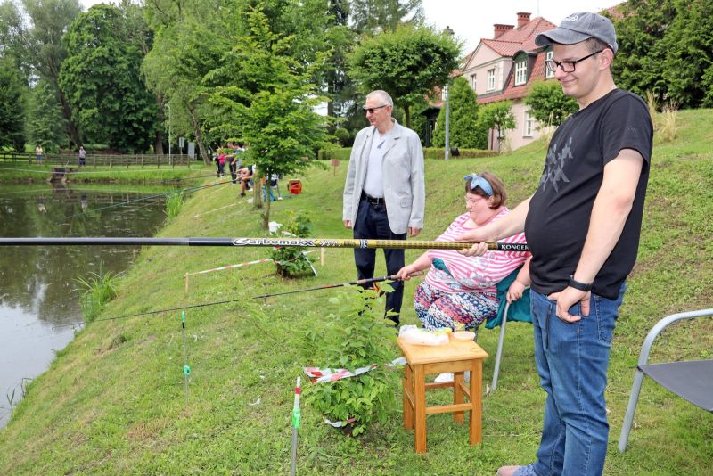 Uczestnicy WTZ łowią ryby podczas międzywarsztatowych zawodów wędkarskich.