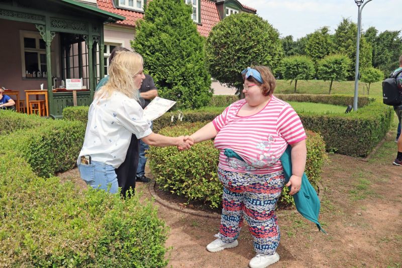 Uczestniczka WTZ odbierająca dyplom po zawodach wędkarskich.